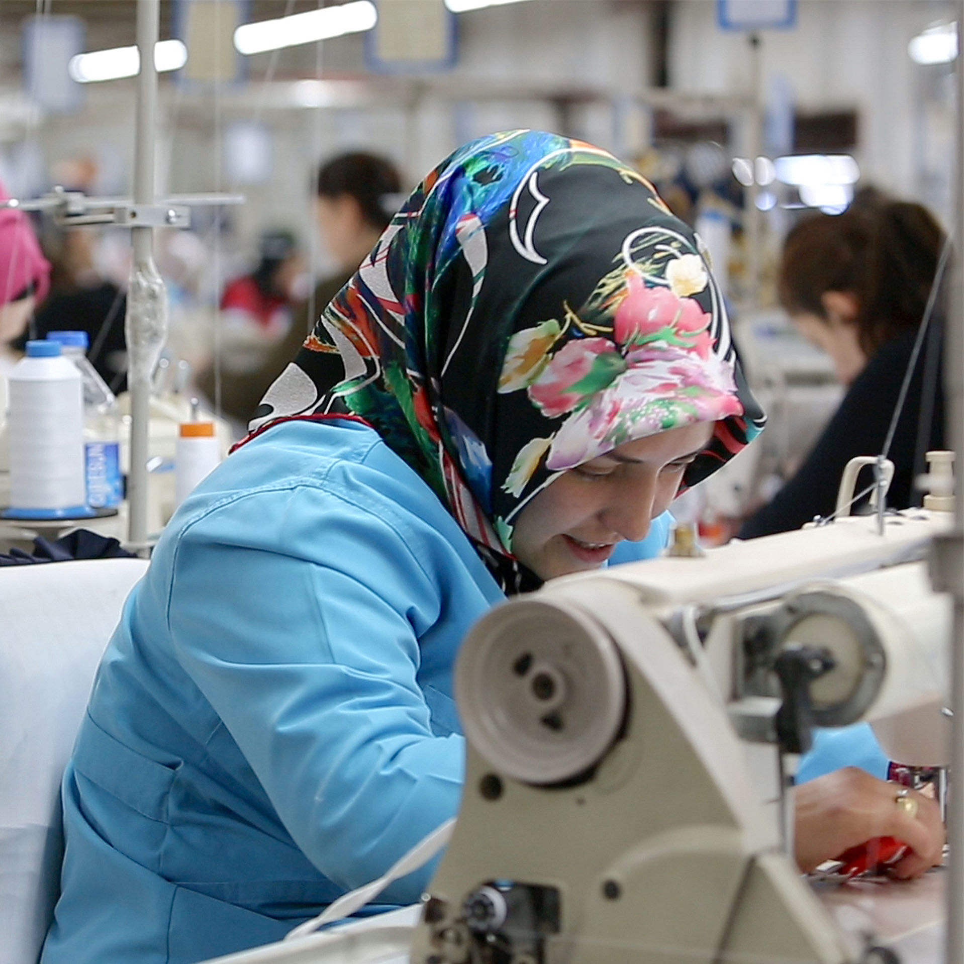 Female factory worker using sewing machine